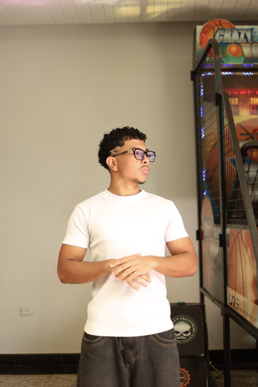 Perfil de Feliphe olhando para o lado, ao lado de uma máquina